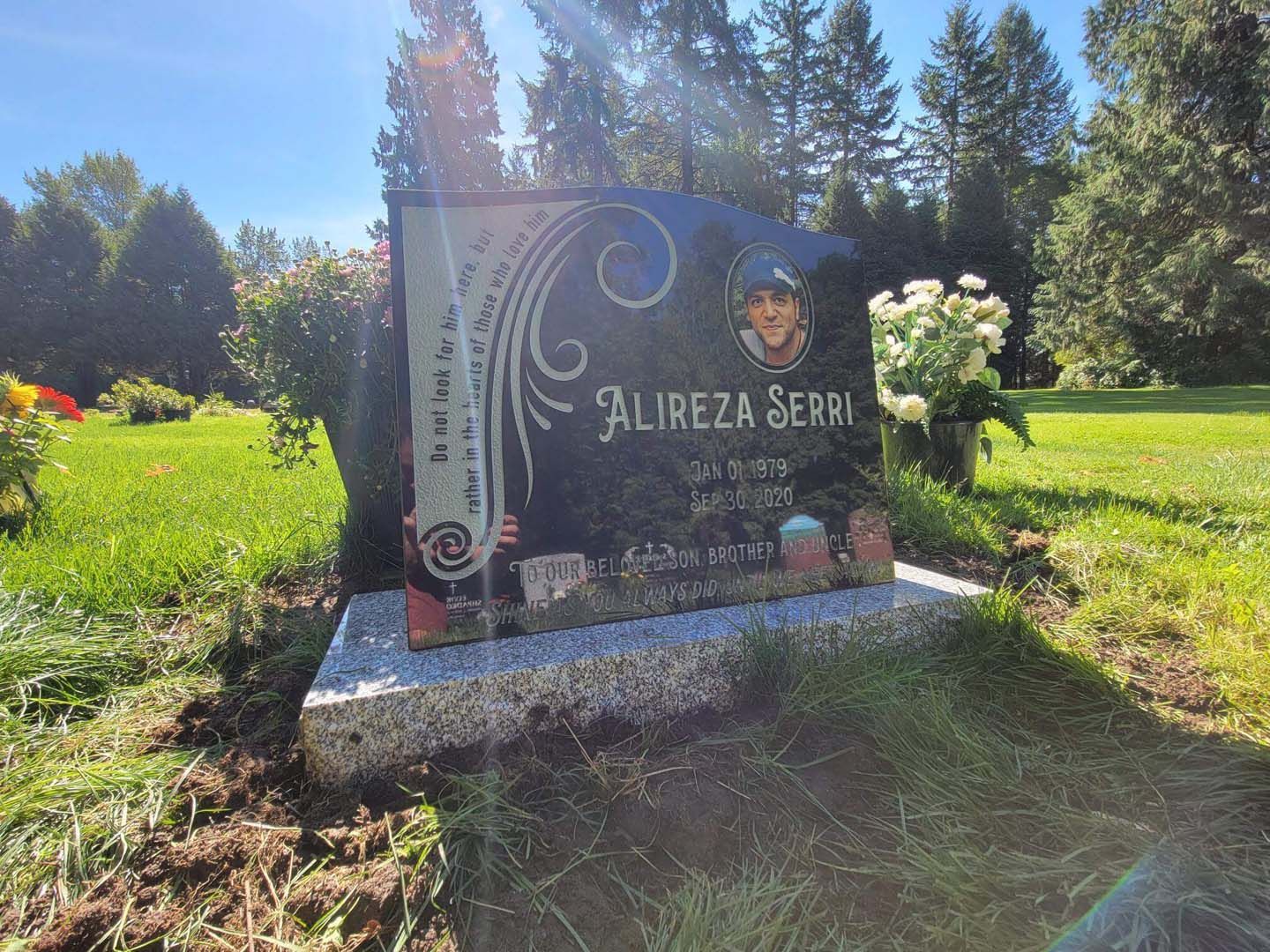 a gravestone in a cemetery with a picture of a man on it .