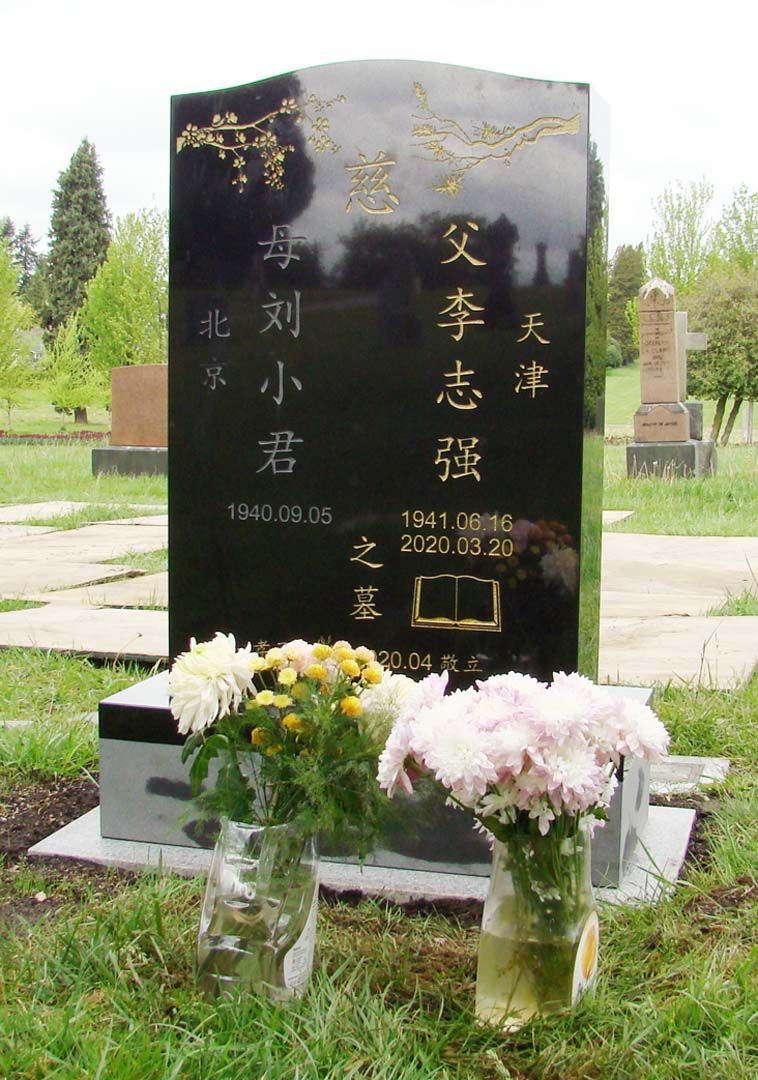 a grave in a cemetery with flowers in front of it