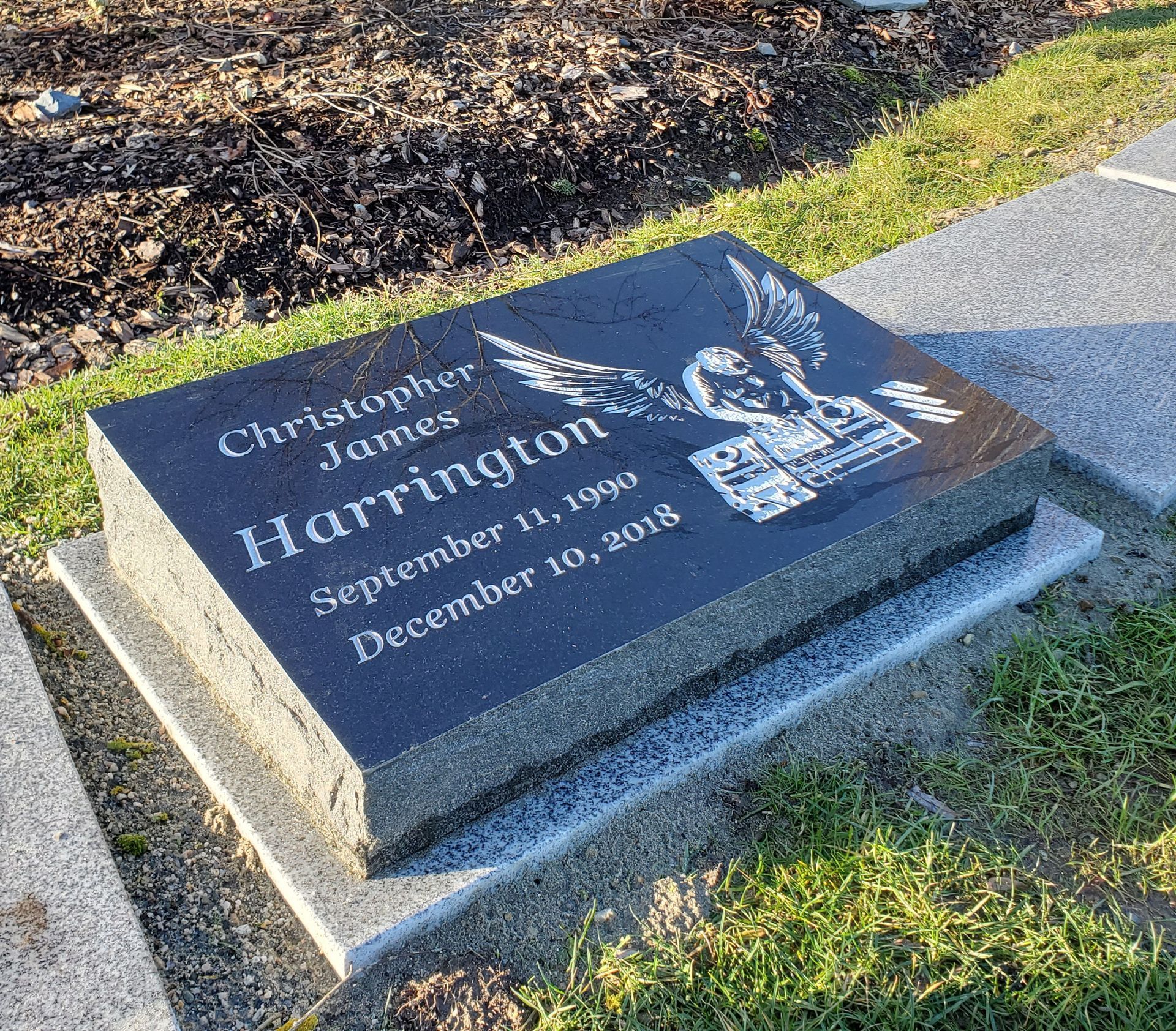 A black gravestone with the name christopher james harrington on it
