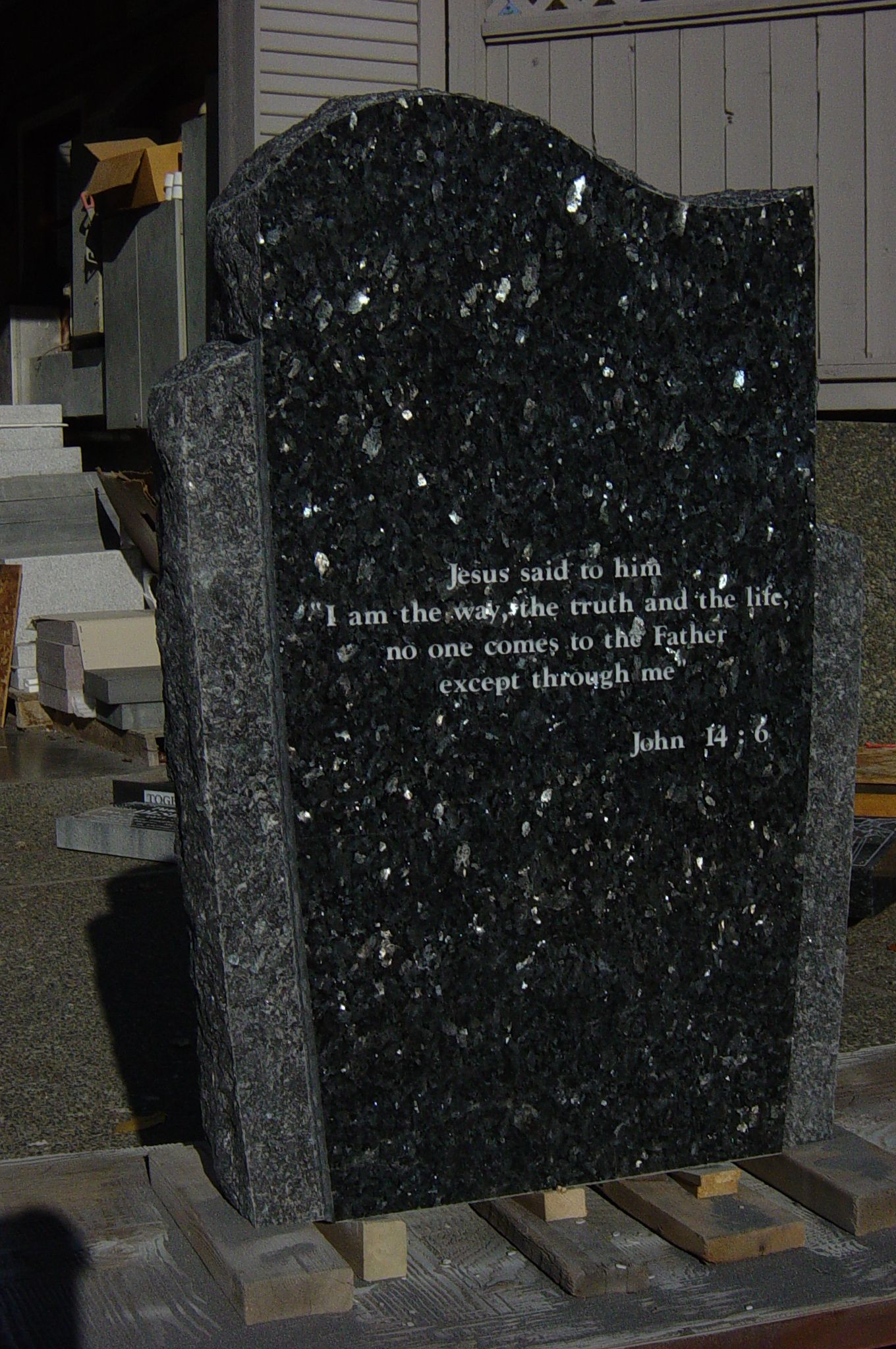 a black gravestone with a poem written on it