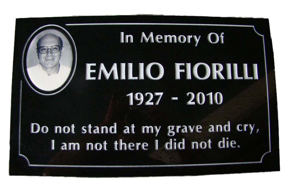 A black plaque that says in memory of emilio fiorilli 1927-2010
