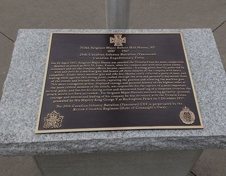 A plaque with a cross on it is on a granite pedestal