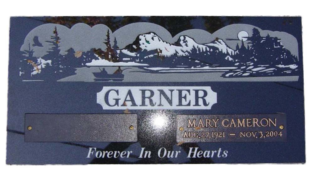 A gravestone for mary cameron garner with a picture of mountains and trees
