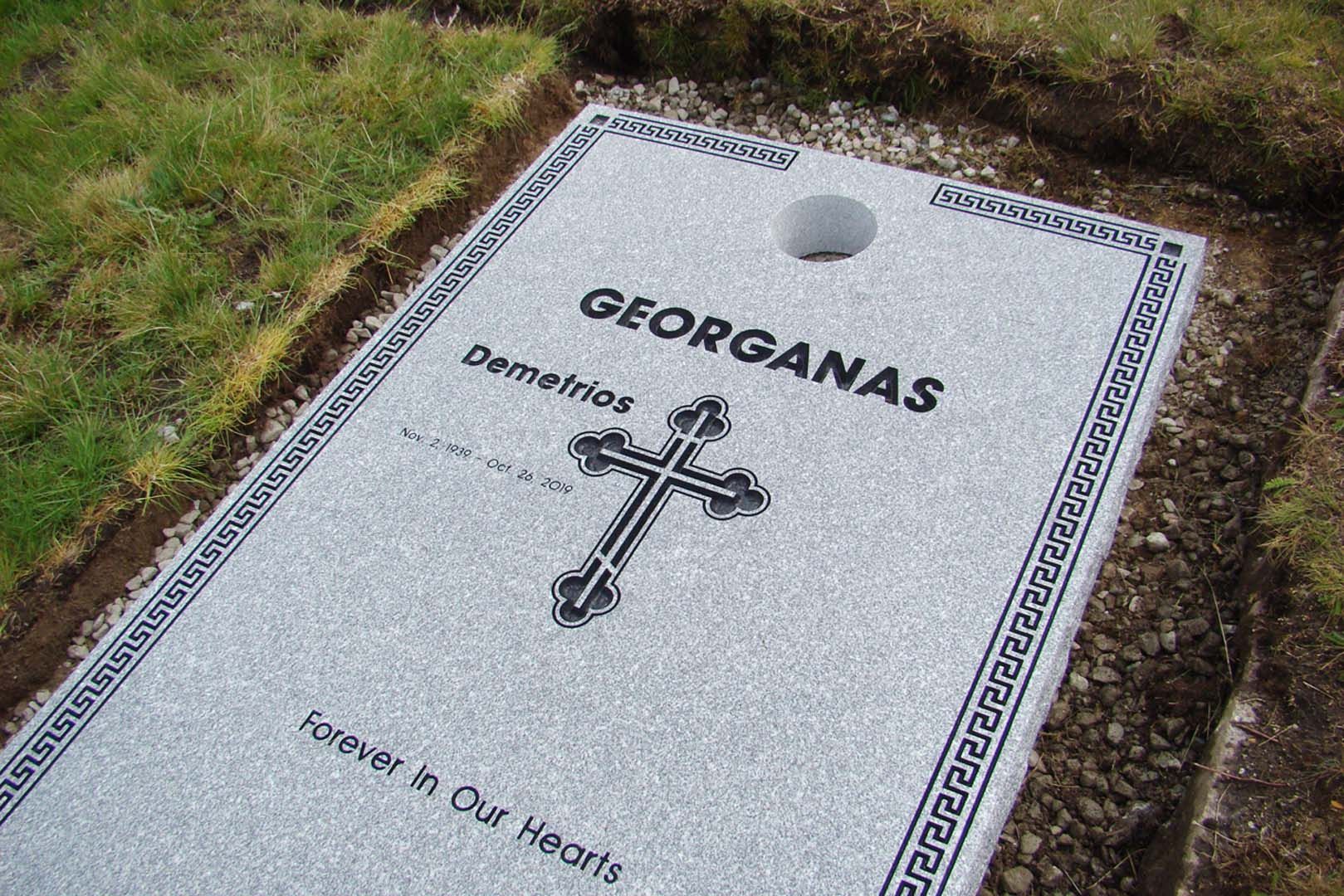 a grave with a cross on it and the name georginas on it .