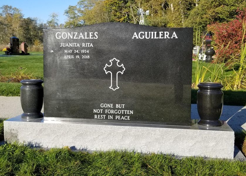 a gravestone for gonzales and aguilera with a cross on it