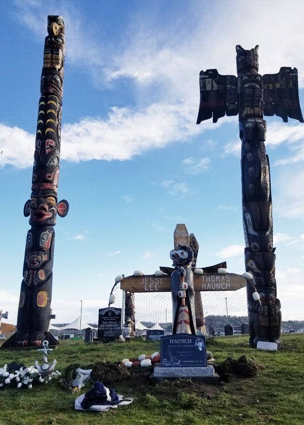 two totem poles and a grave in a cemetery