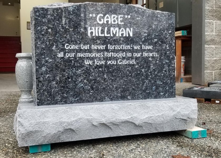 a gravestone for gabe hillman is sitting on the ground .