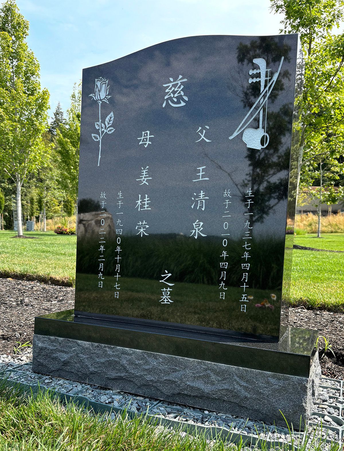 Photo of a black granite upright memorial marker with Chinese lettering in white.