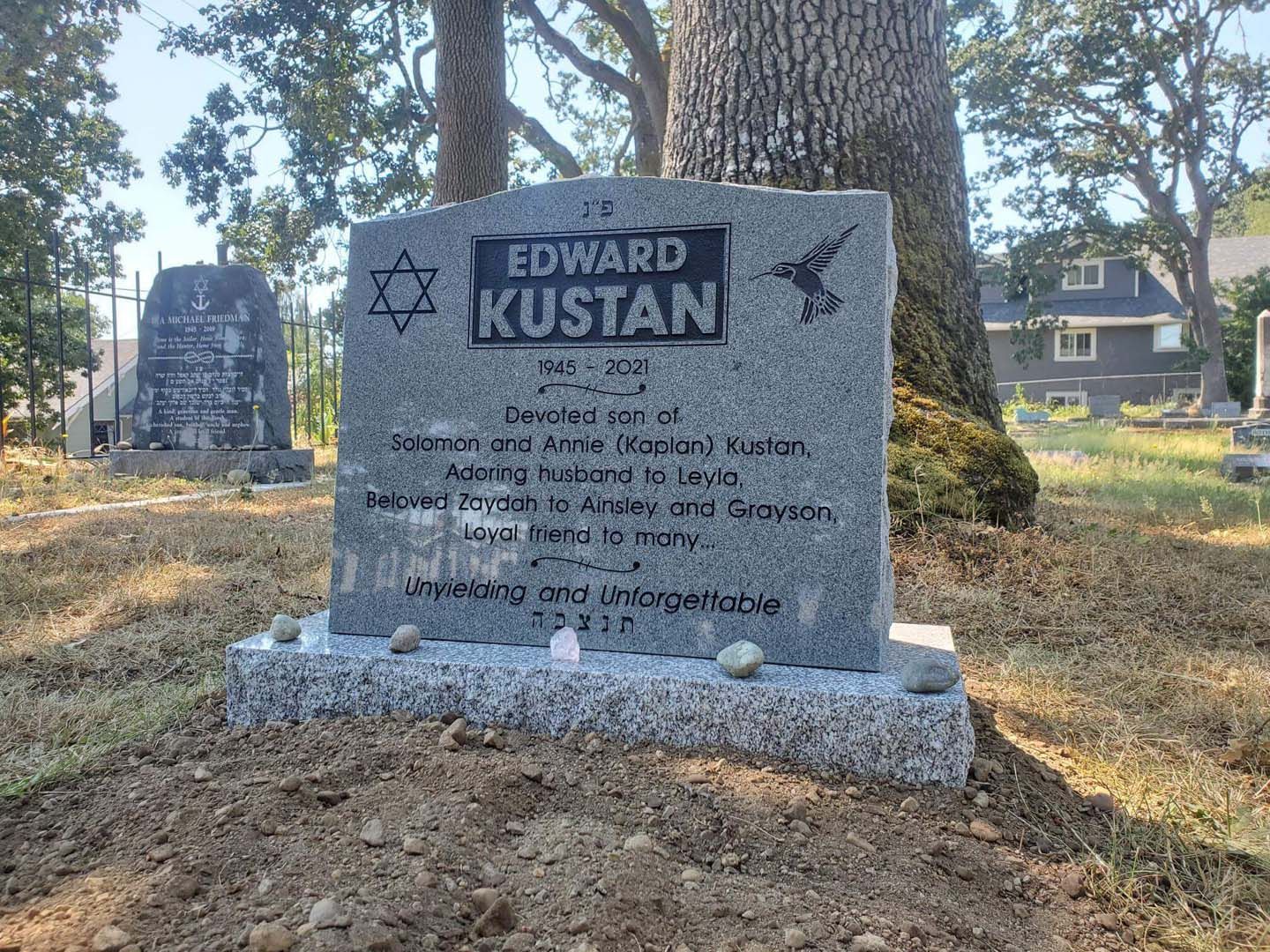a gravestone for edward kustan is in a cemetery .
