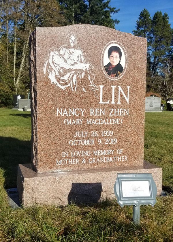 a gravestone for nancy ren zhen in a cemetery with a picture of her on it .