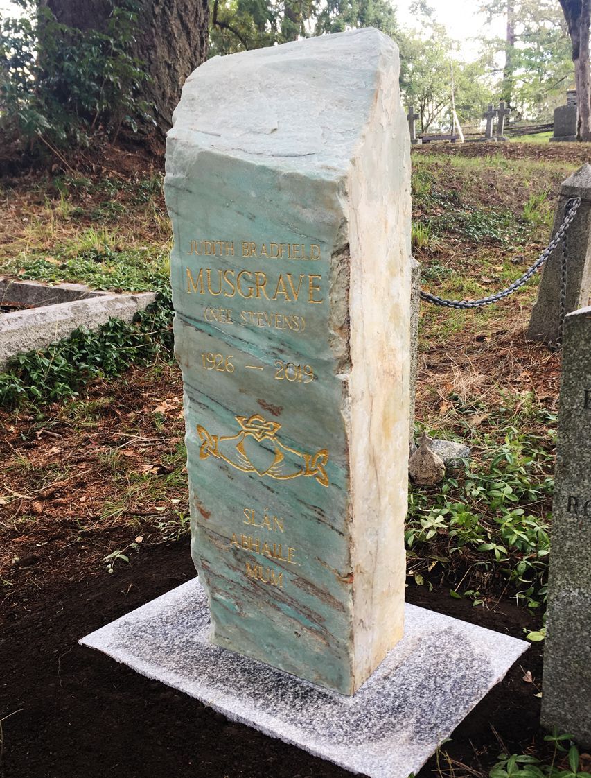 a large stone sculpture is sitting on top of a white table in a cemetery .