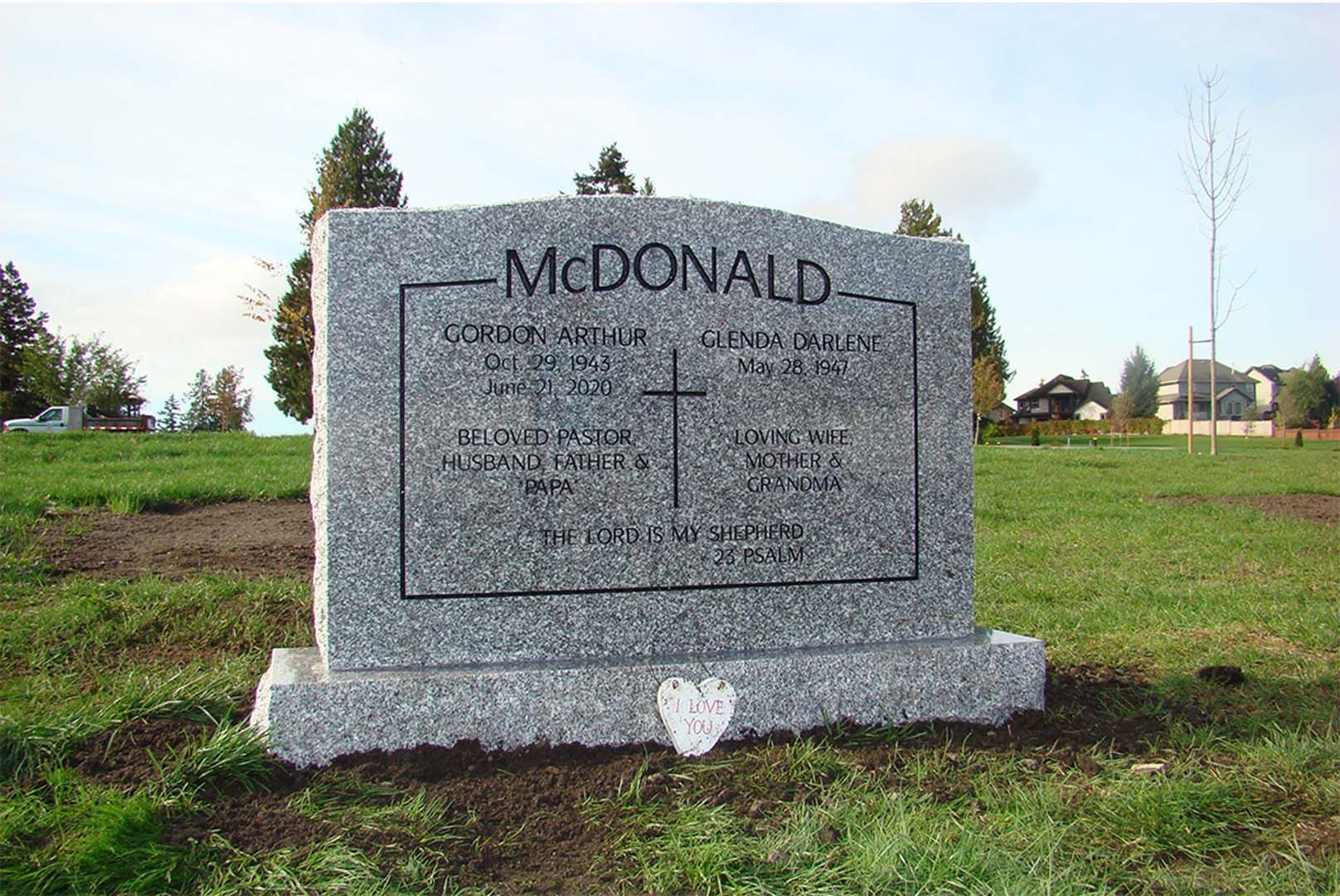 a gravestone for mcdonald is in a grassy field