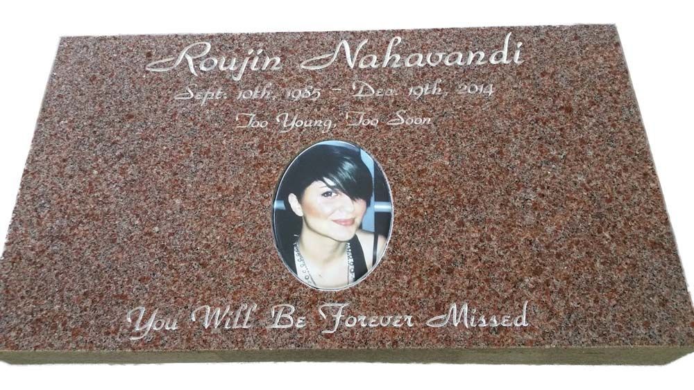 A gravestone with a picture of a woman on it.