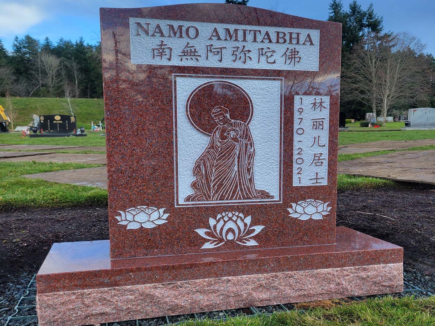 a gravestone in a cemetery with chinese writing on it