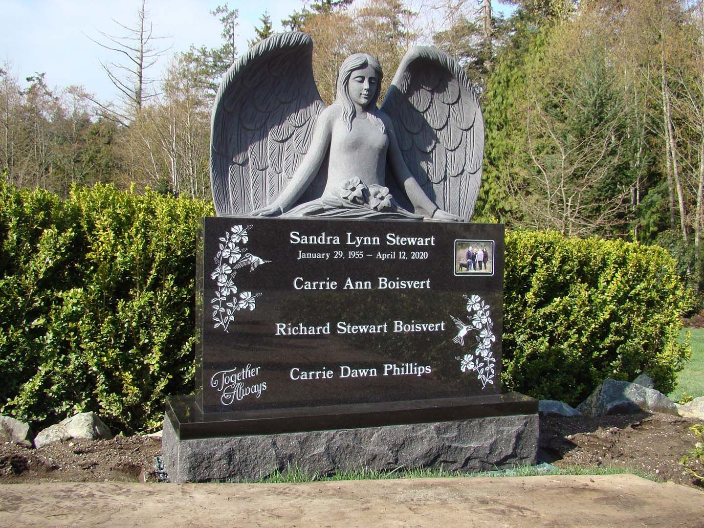 a statue of a woman with wings is on a grave