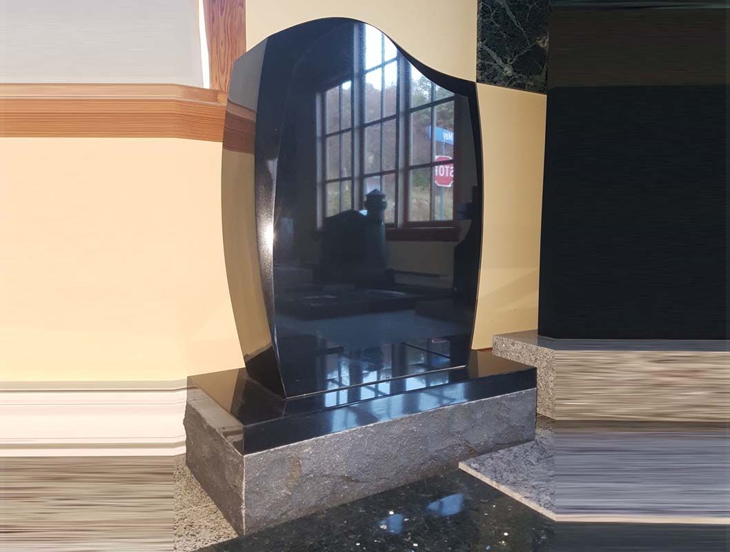 A black gravestone is sitting in front of a window