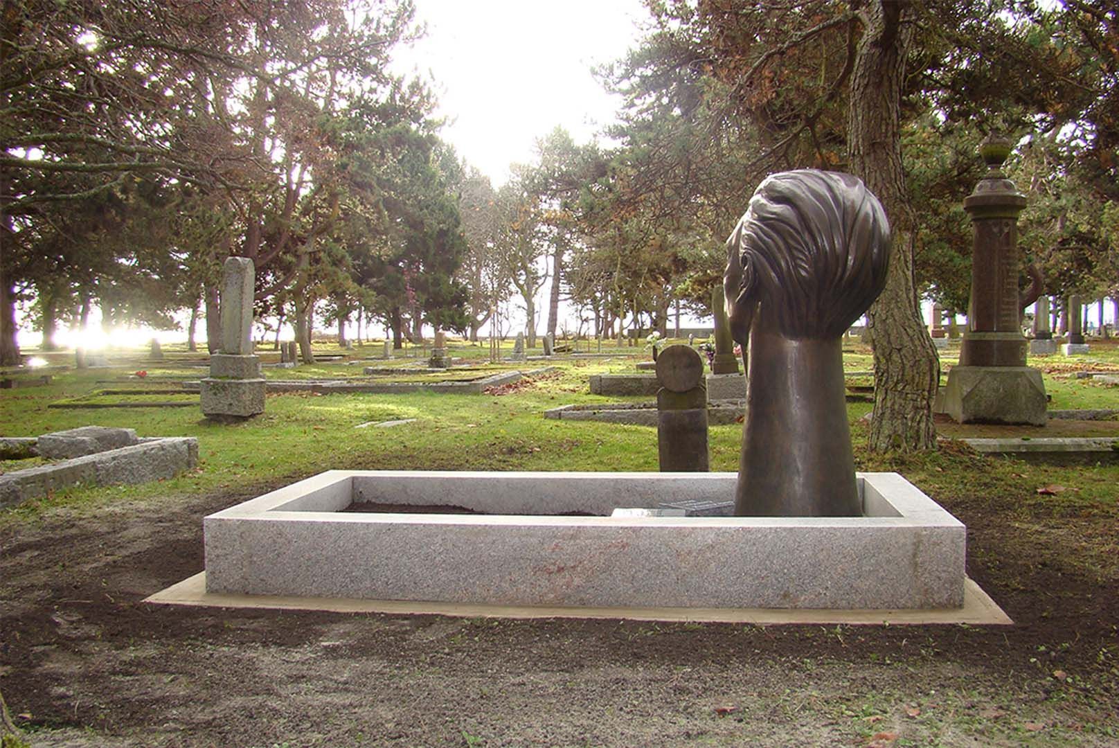 a grave in a cemetery with trees in the background