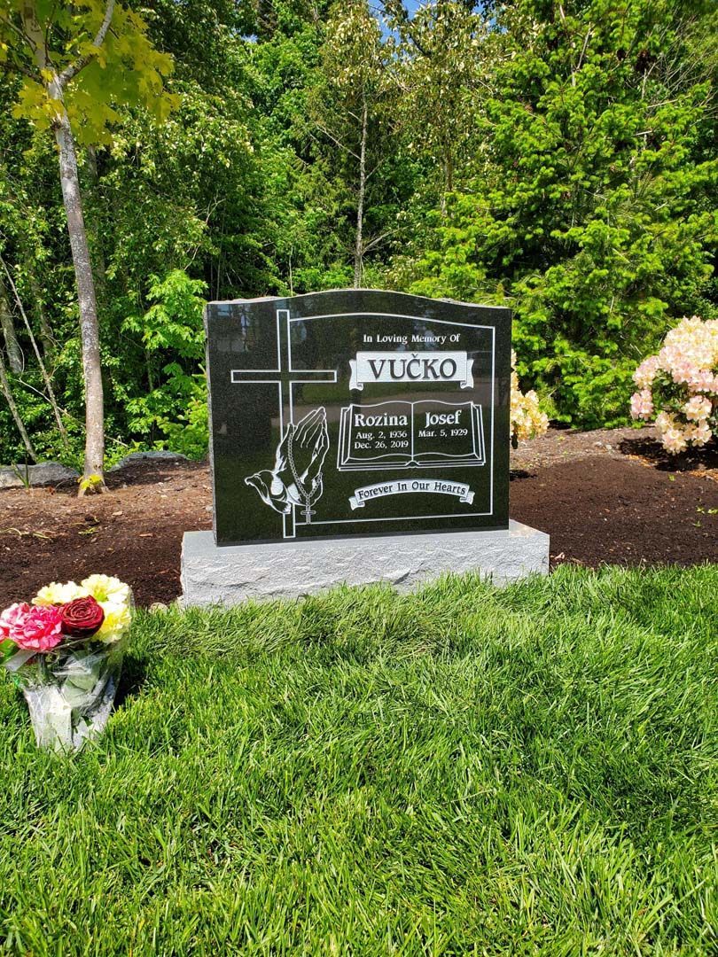 a gravestone in a cemetery with flowers and trees in the background .