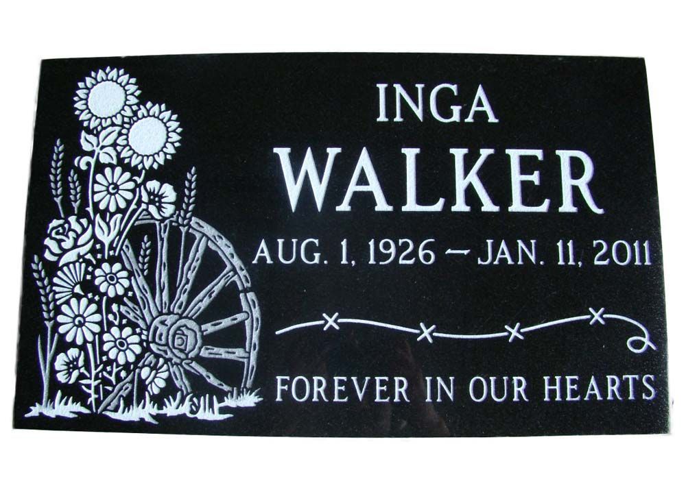 A gravestone for inga walker with flowers and a wagon wheel