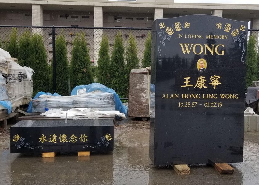 a large black gravestone with the name wong on it