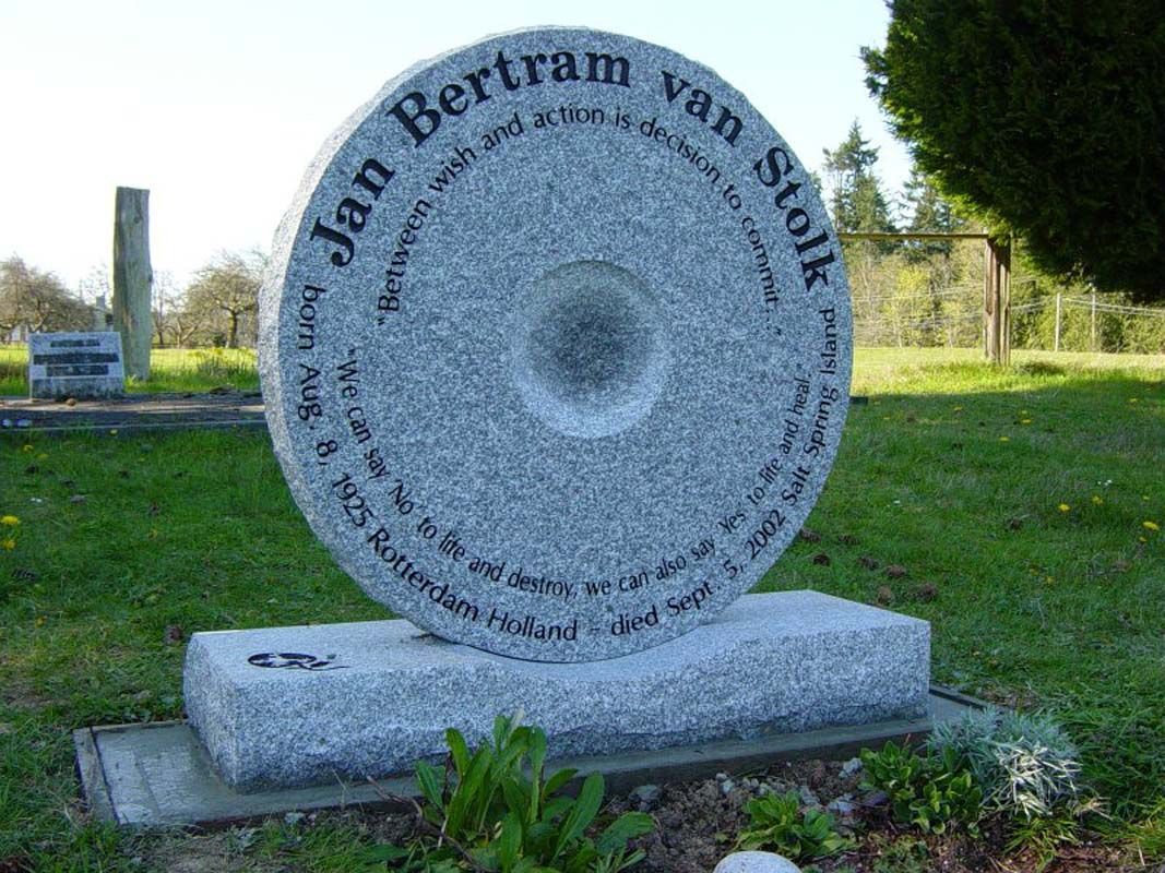 A gravestone in the shape of a wheel in a cemetery.