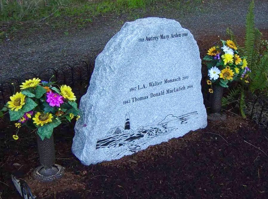 a gravestone with flowers in front of it in a cemetery