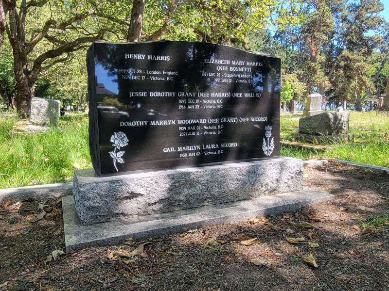 a gravestone in a cemetery with trees in the background