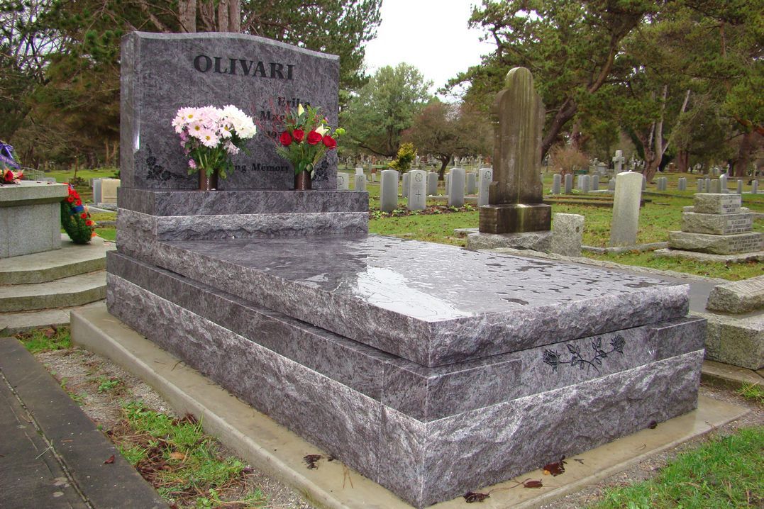 a grave in a cemetery with flowers on it .