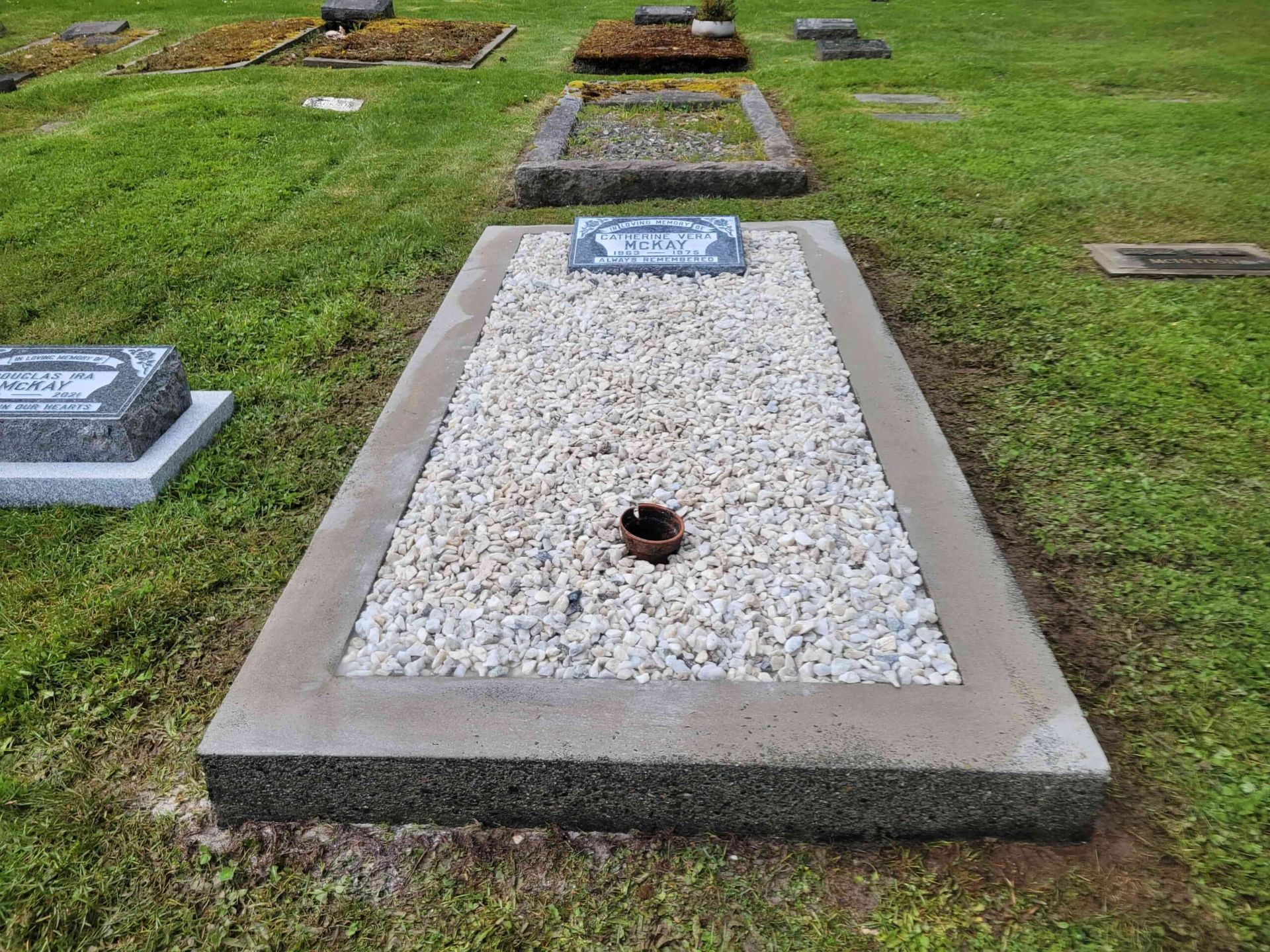 a grave in a cemetery with graves in the background .