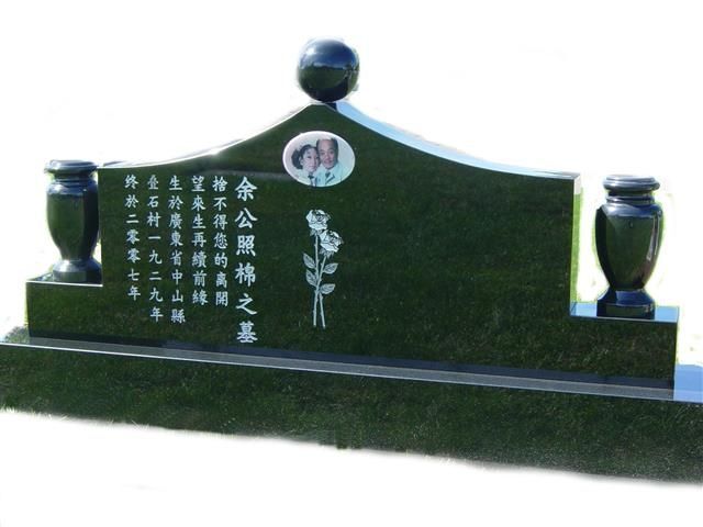 a green gravestone with chinese writing on it