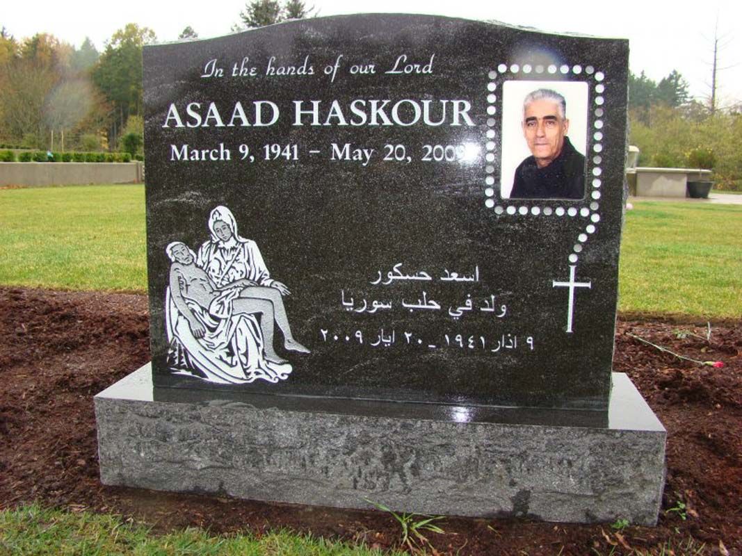 A black gravestone with a picture of a man named asad haskour