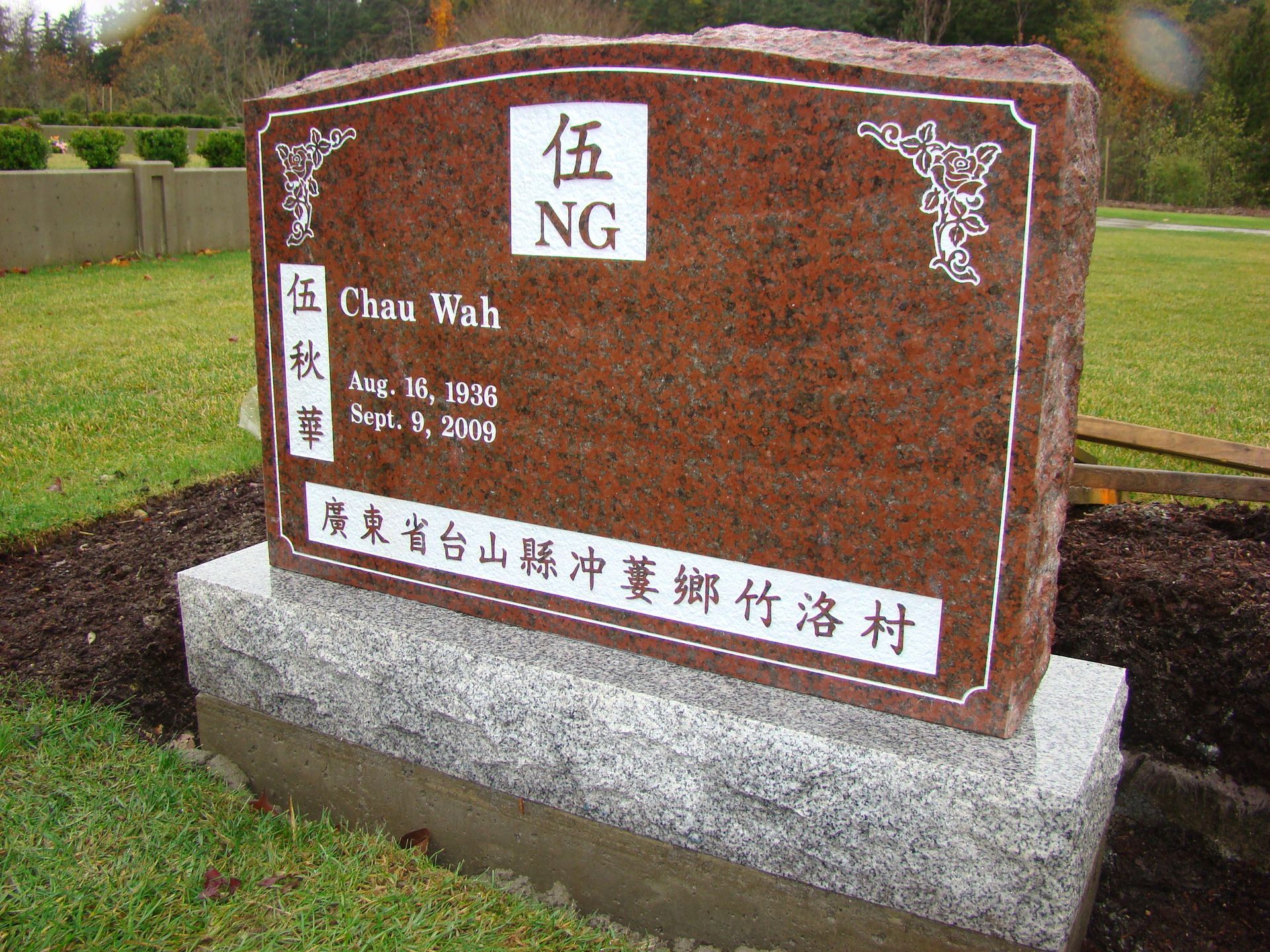 a gravestone in a cemetery with chinese writing on it