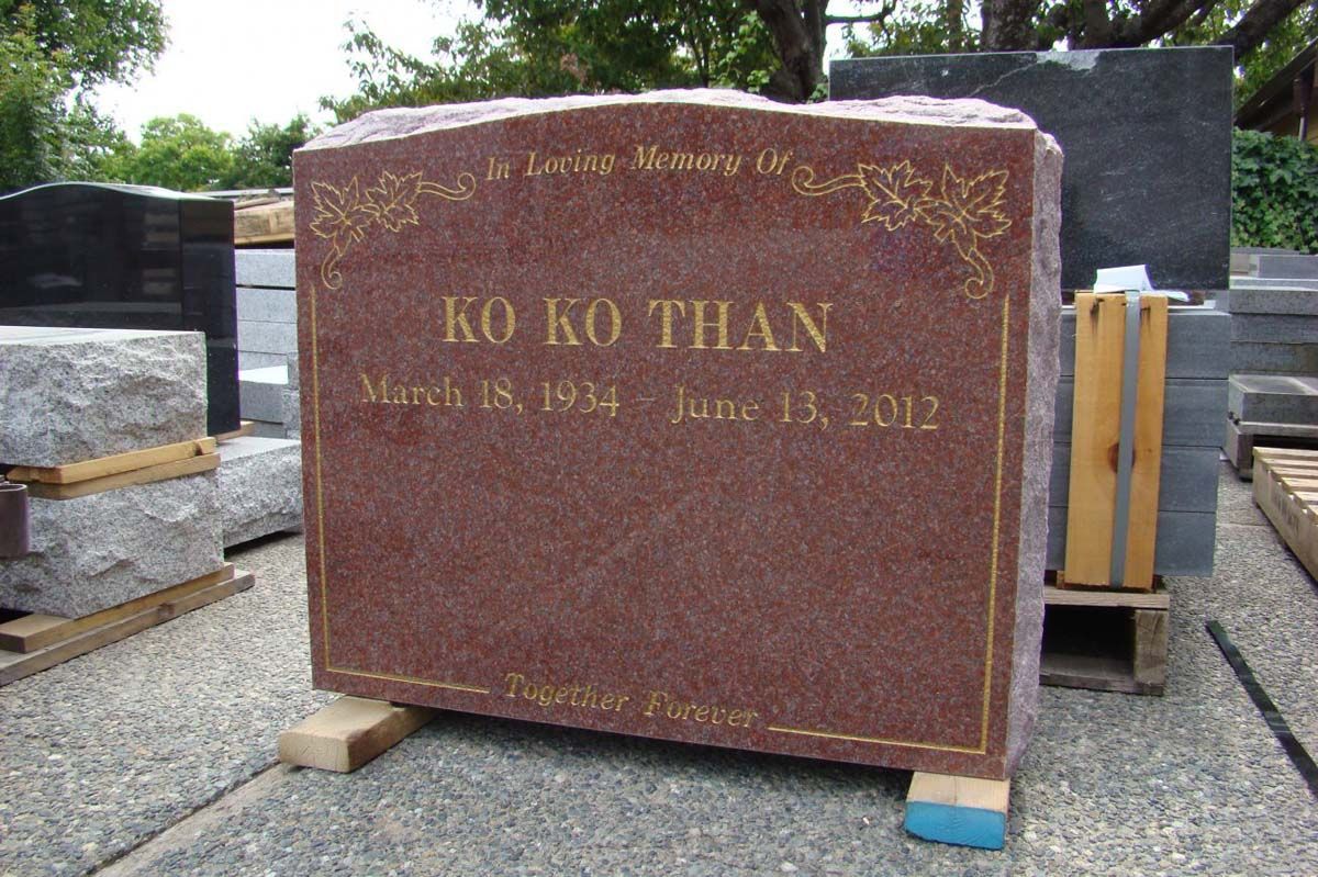 A red gravestone with the name ko ko than on it