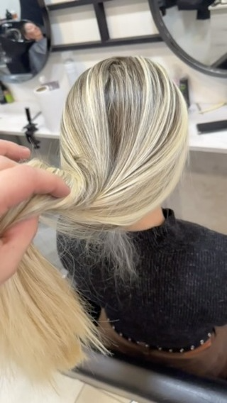 Una mujer se está peinando en un salón.