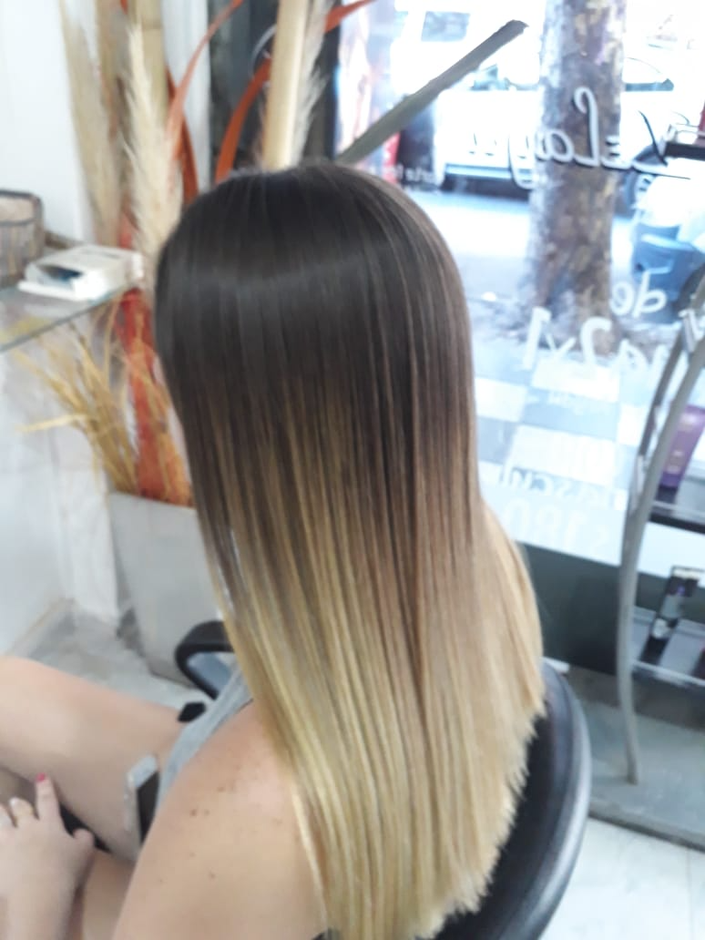 Una mujer con cabello largo está sentada en una silla.