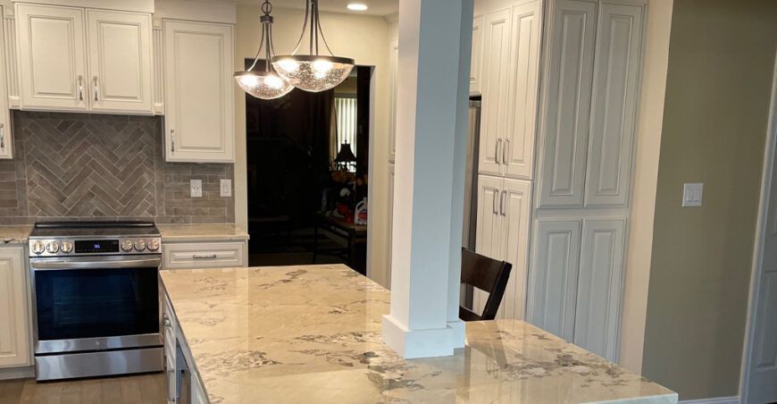Kitchen with white cabinets, granite countertops, and stainless steel appliances.