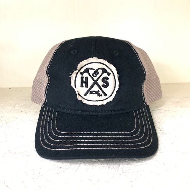 Black and tan trucker hat with white, distressed HXS logo.