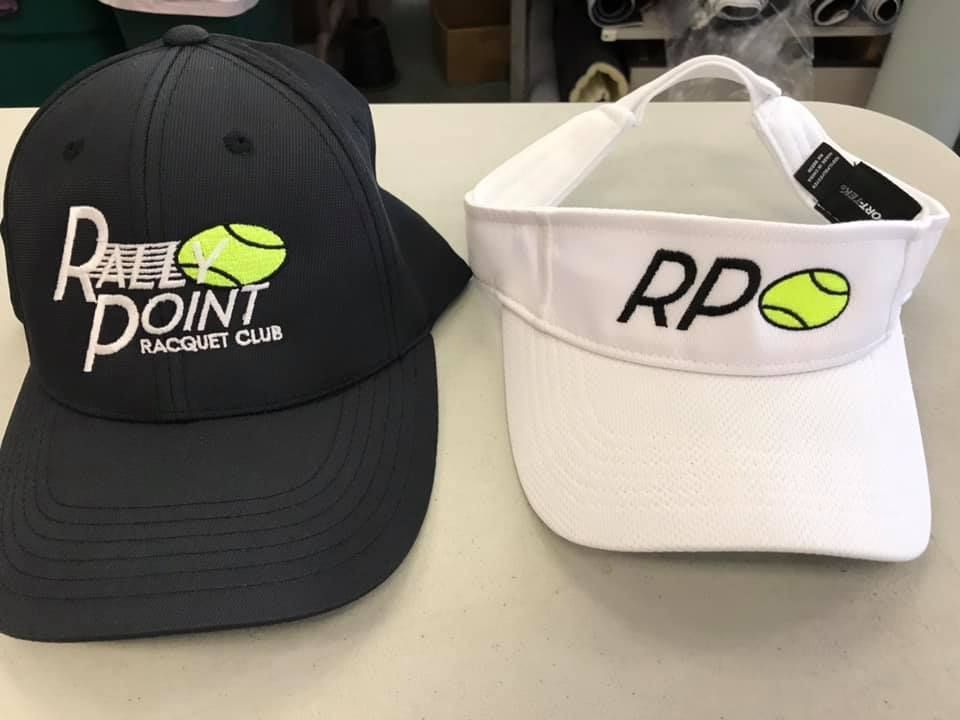 Black hat and white visor with tennis ball logos and 