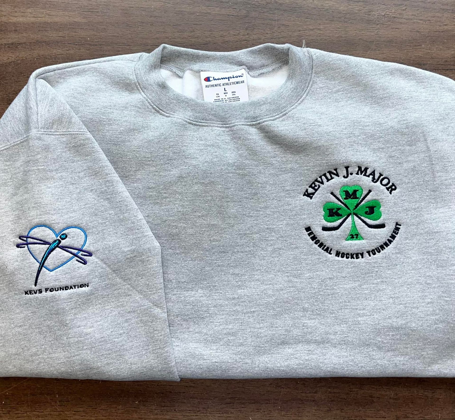 Grey Champion sweatshirt with embroidered shamrock and dragonfly logos. 