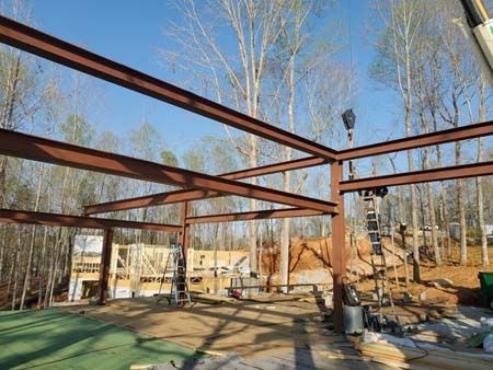 A large metal structure is being built in the middle of a forest.