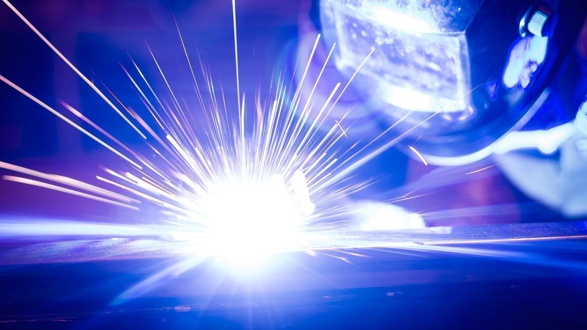 A close up of a person welding a piece of metal.