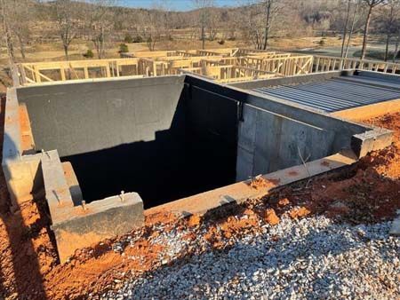 A large concrete structure is being built in the middle of a dirt field.