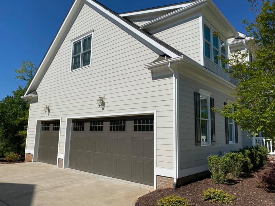 Two-story house with gray siding and a brown garage door.