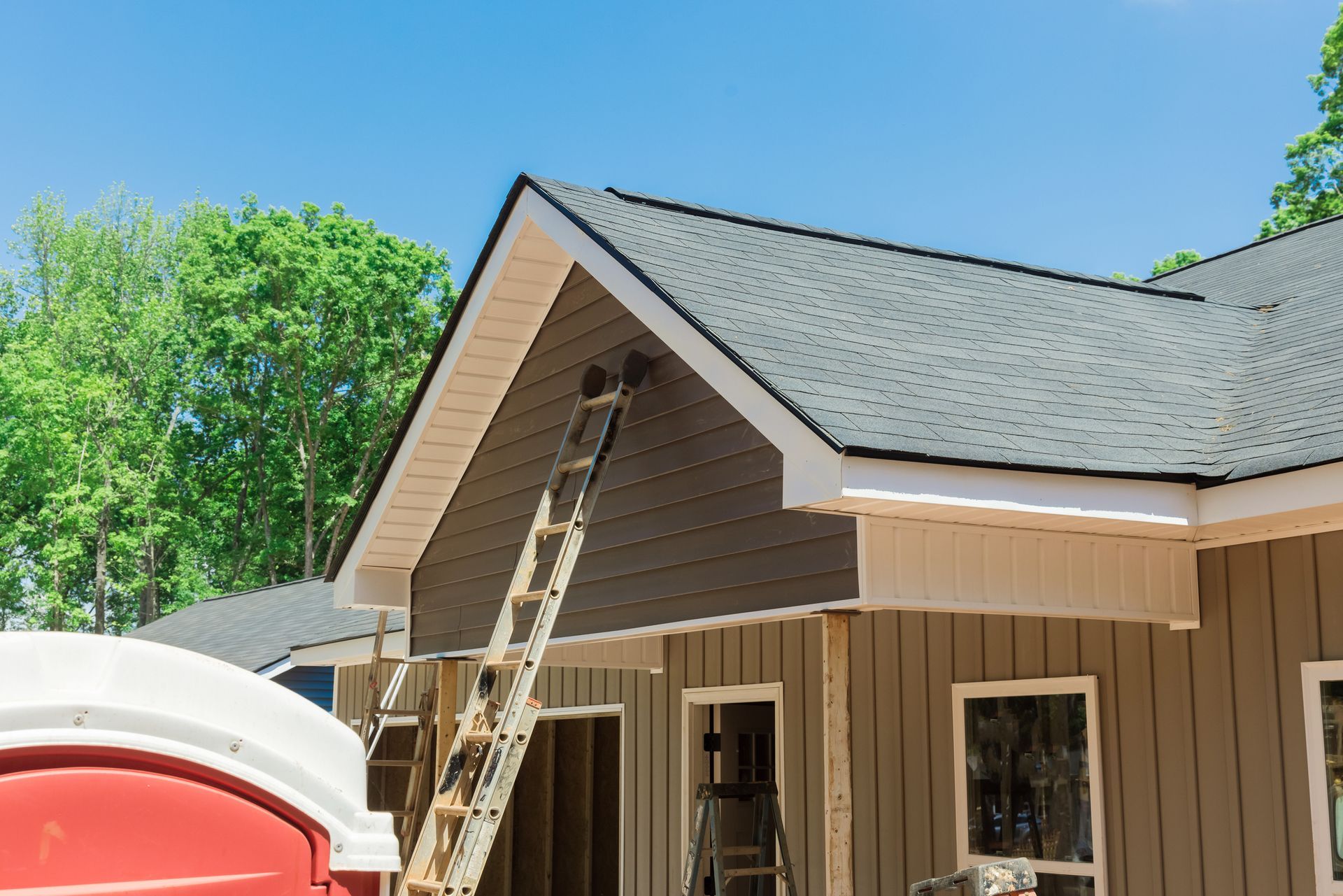 Residential roofing project showing roof tiles on newly built house at active construction site.