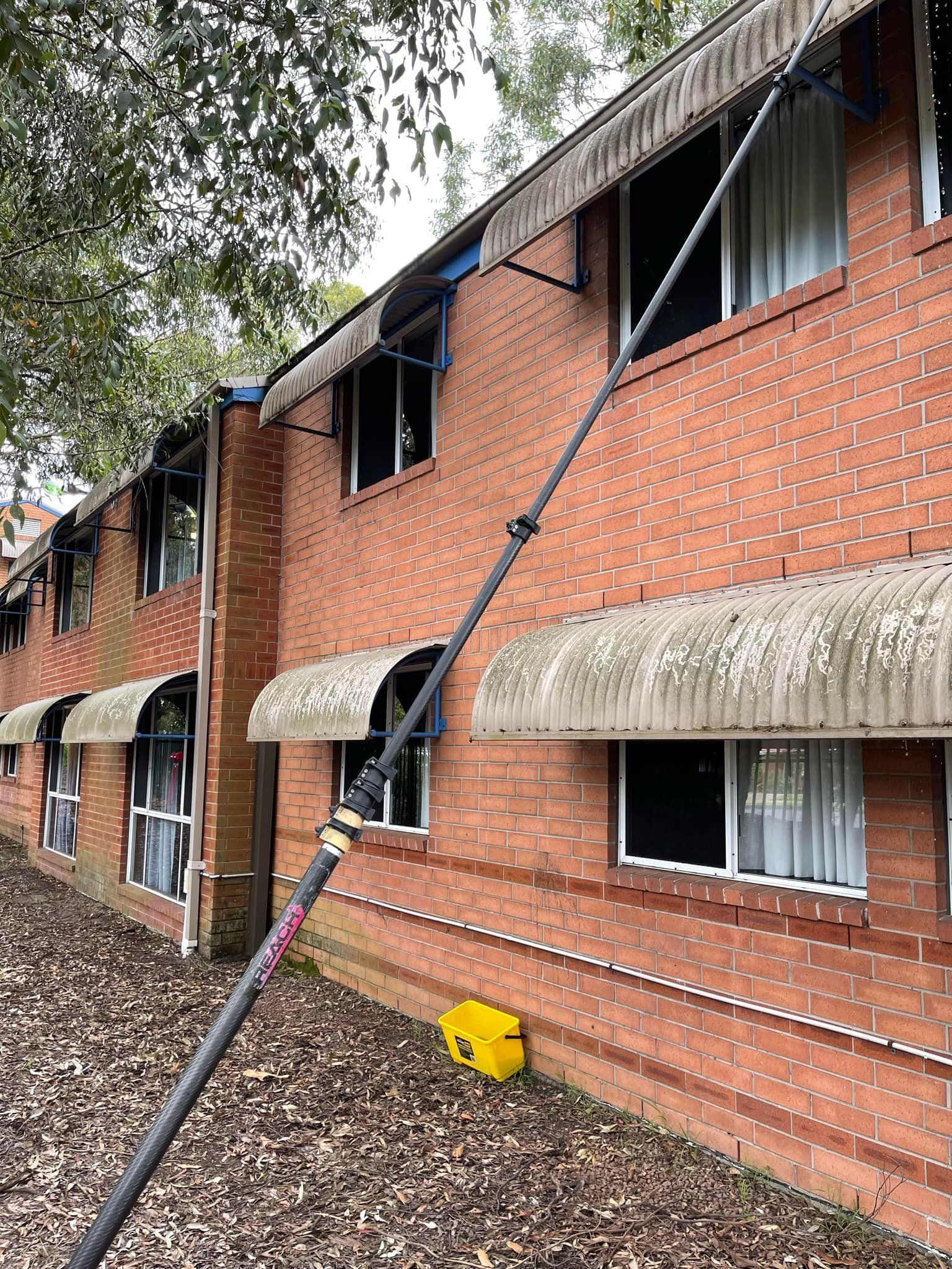 water fed pole system resting on building wall