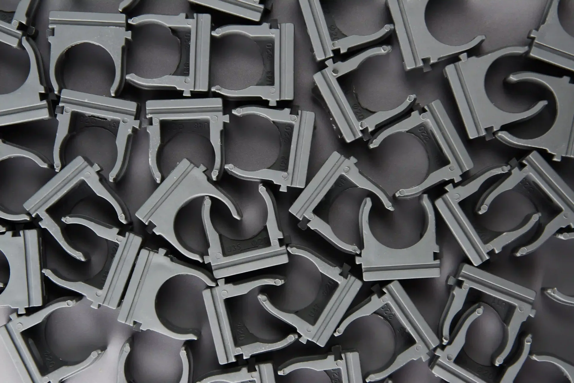 Pile of gray plastic pipe clamps.