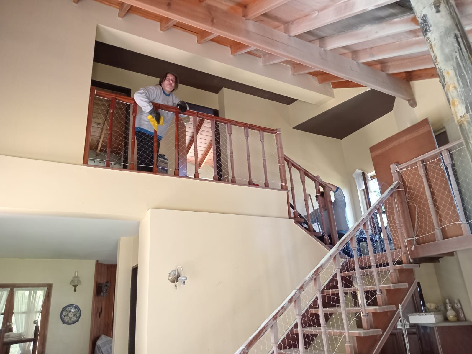Un hombre está de pie en un balcón con vistas a unas escaleras.