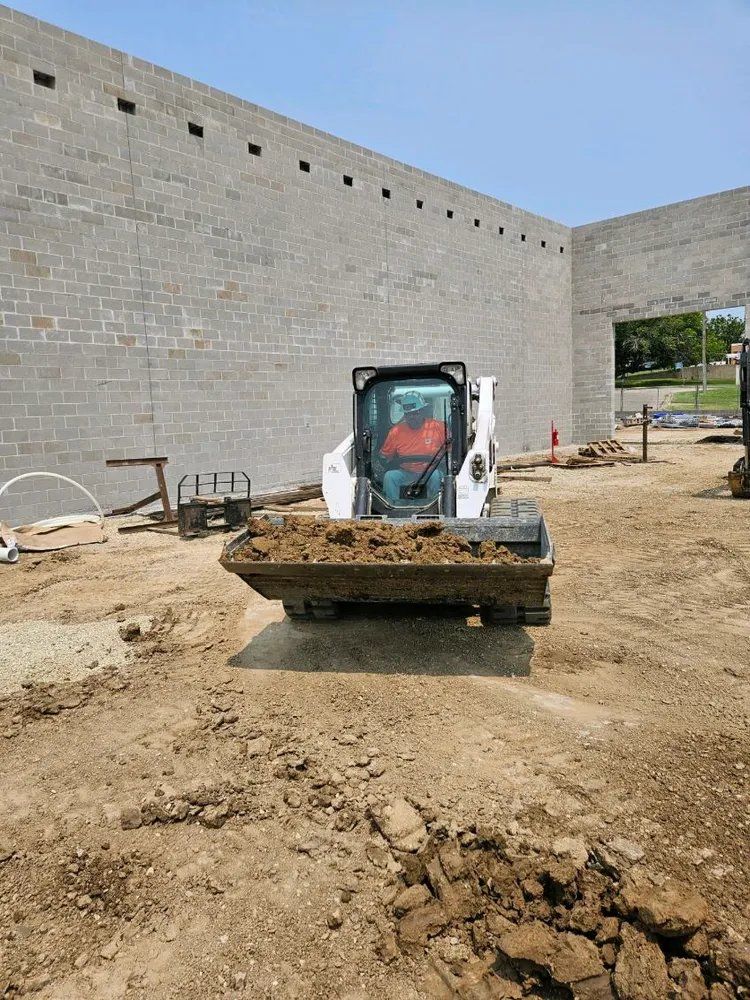 A bulldozer is moving dirt in front of a building under construction.