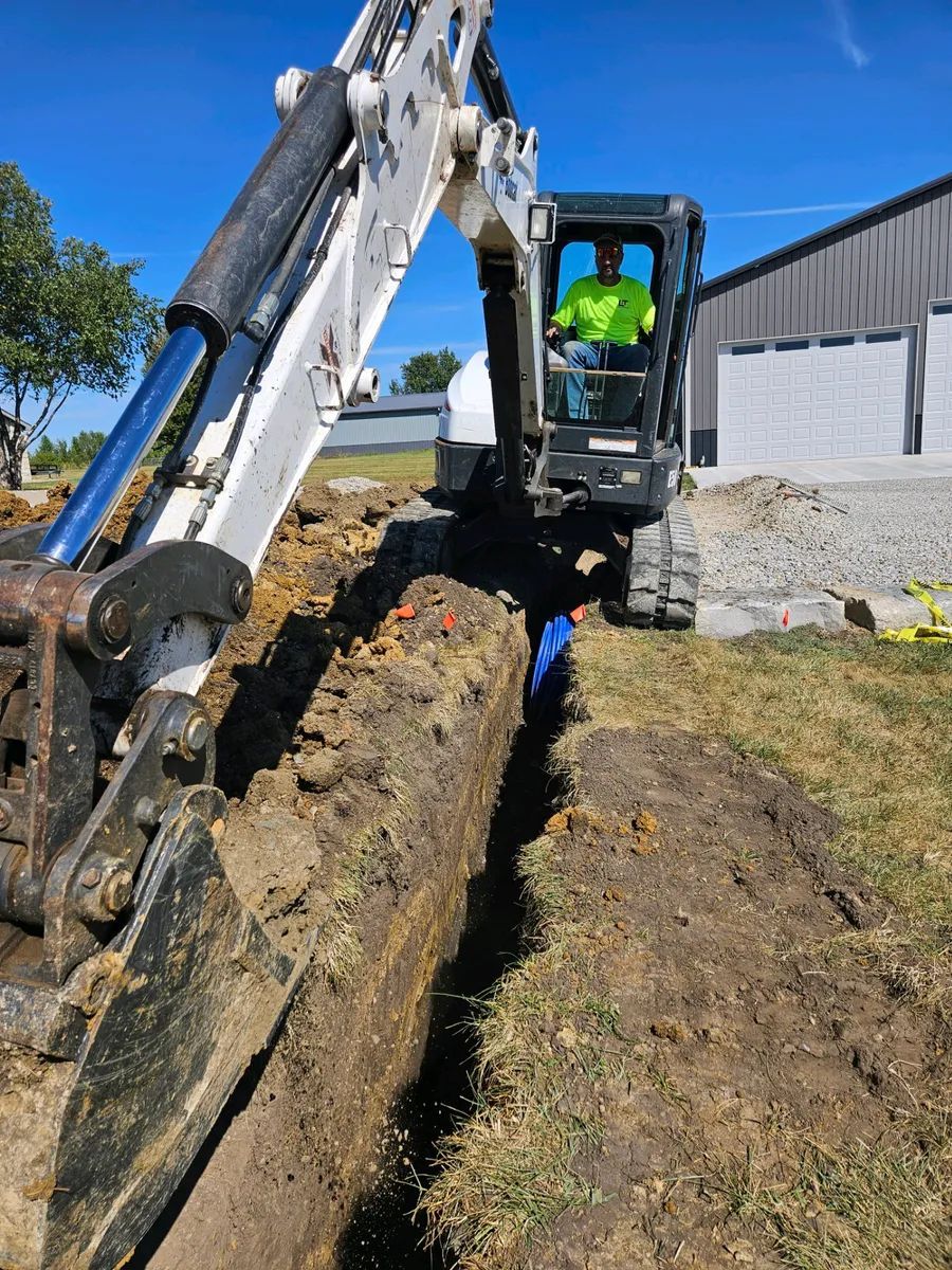 A man is driving a bulldozer in a dirt field