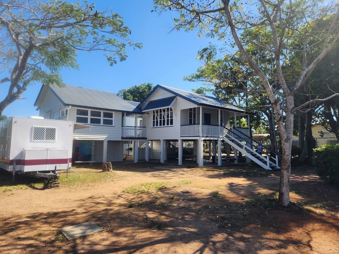 A large white house with a trailer parked in front of it.